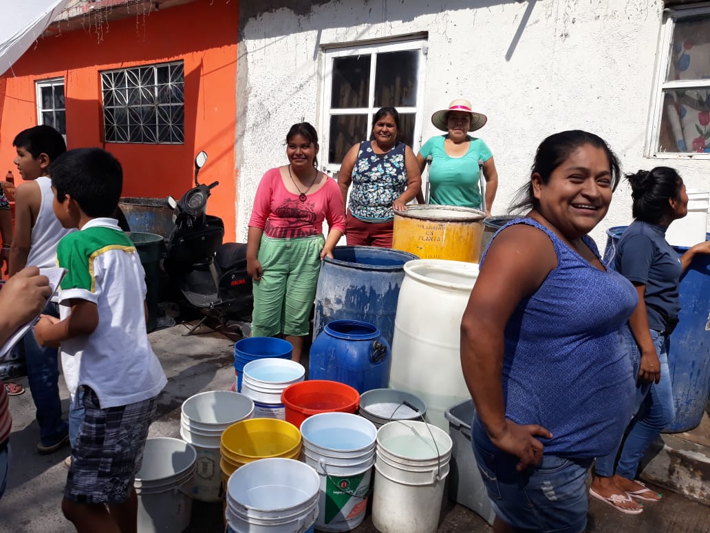 Después de un mes sin agua os vecinos llenan su trastes. Foto cortesía