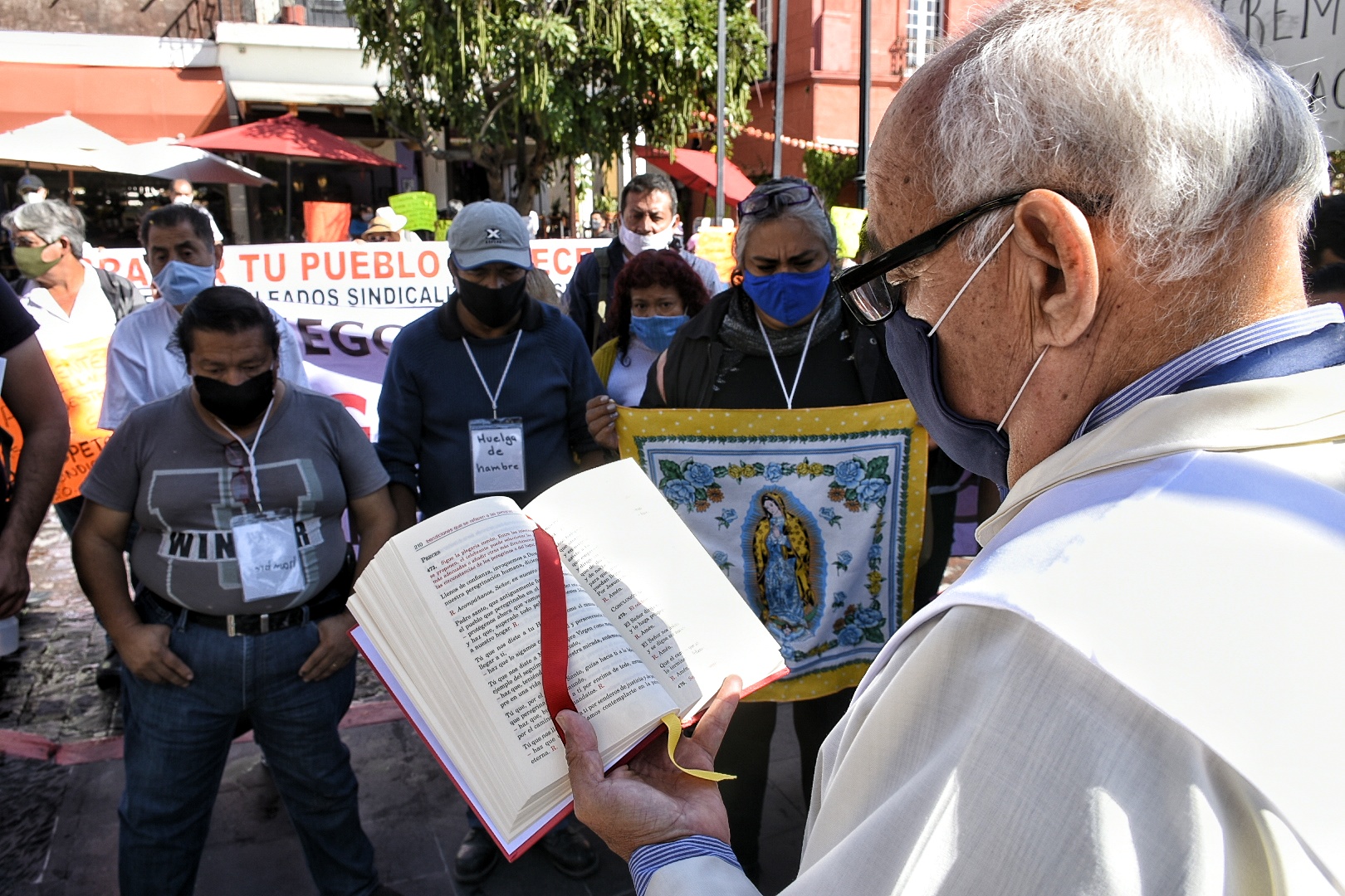 Huelguistas y sacerdote 